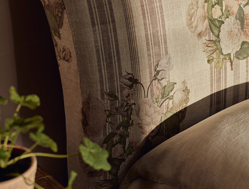 Arles king bed in Spill Resistant RHS Etta's Bouquet Alba Truffle with bolster in Almost Plain Velvet Spring fabric detail